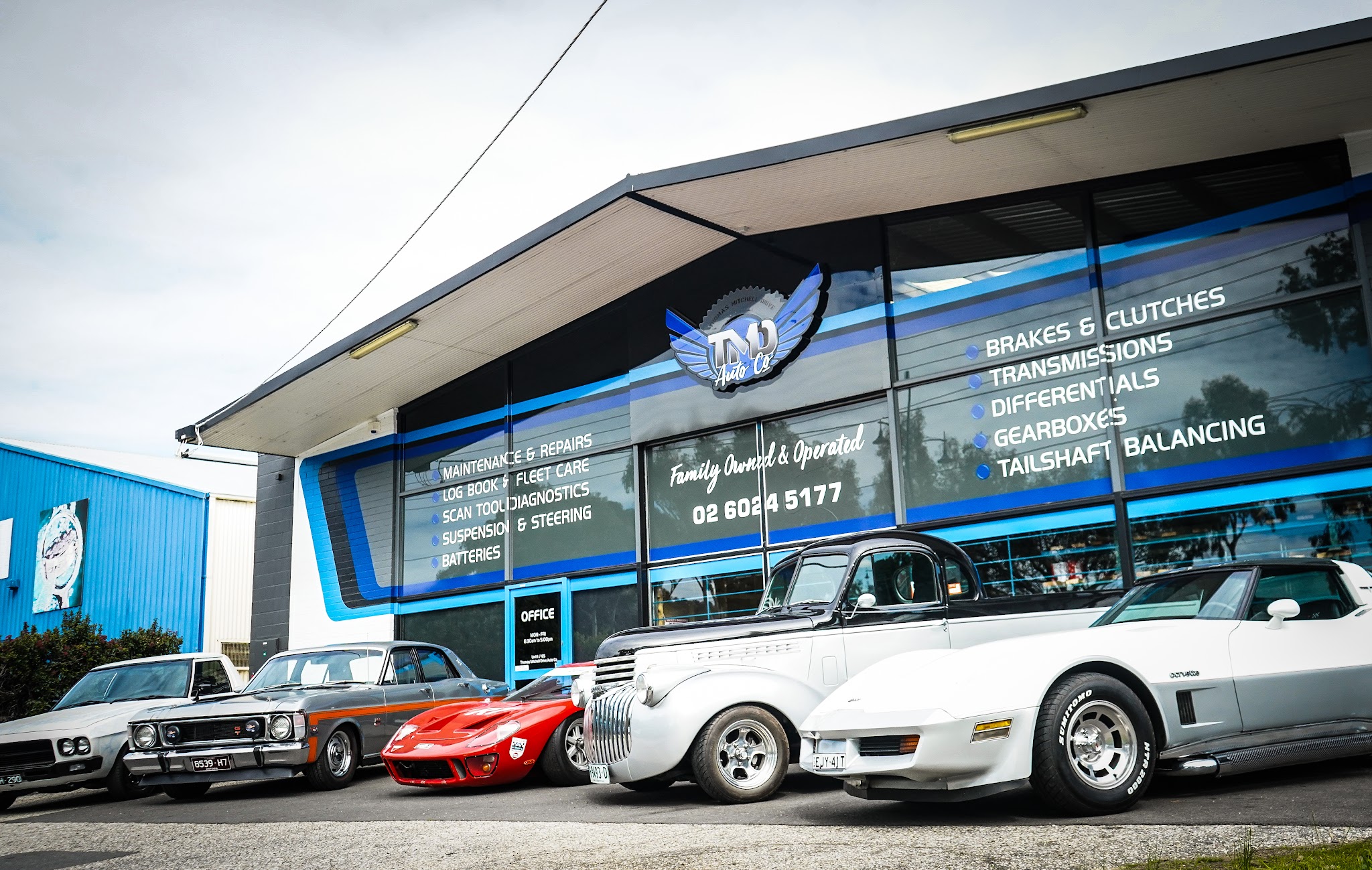 The TMD Auto Co. workshop on Thomas Mitchell Drive with classic cars parked out front