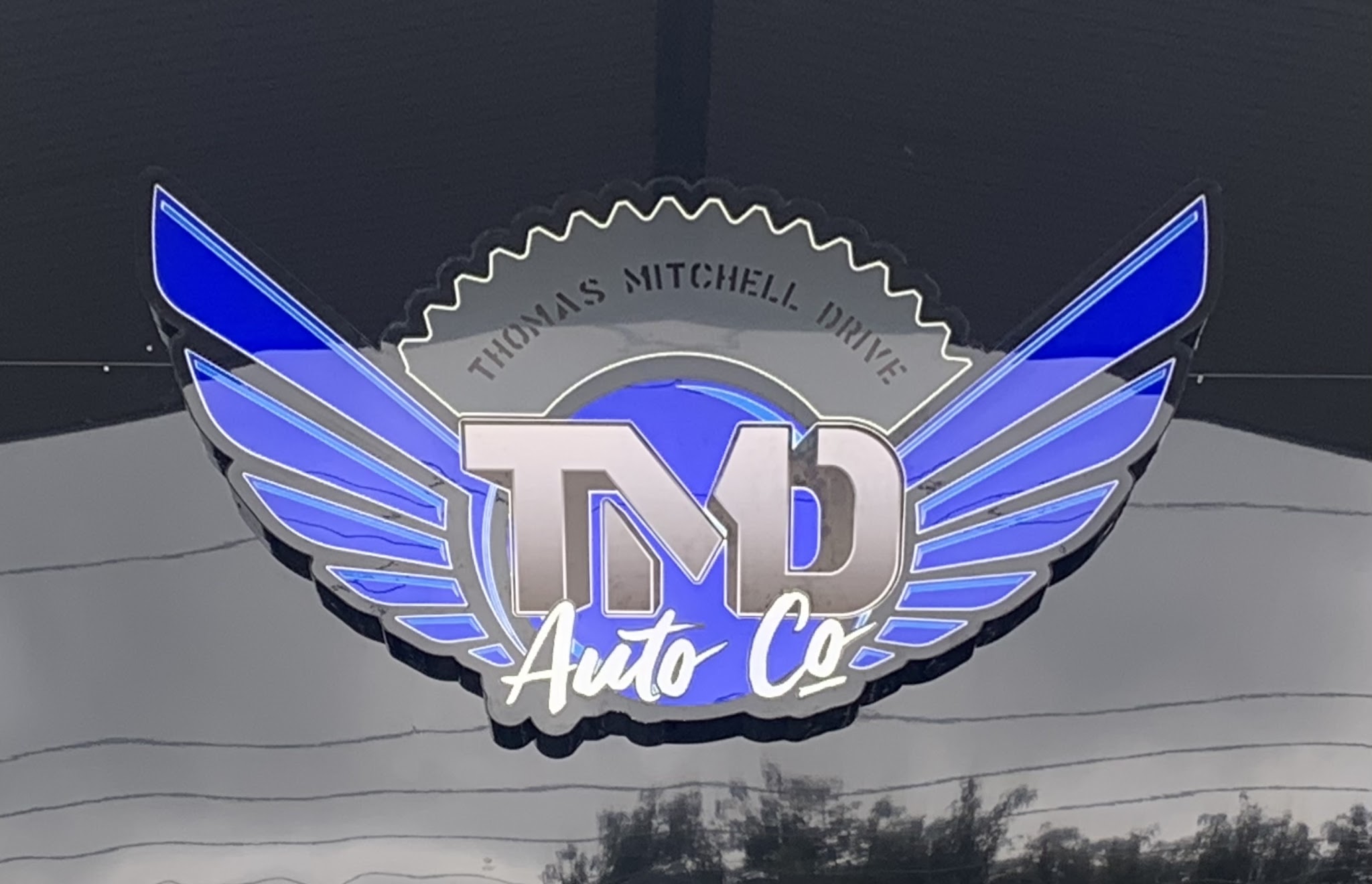 The illuminated TMD Auto Co. badge on the front of the Wodonga workshop